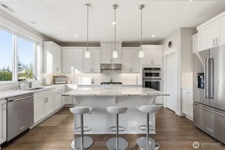The spacious kitchen island serves as the heart of the home, offering ample prep space and casual seating for family and guests. Perfect for entertaining or everyday living, it blends functionality with inviting style.