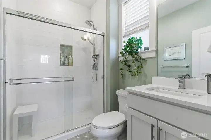 The main floor guest bath combines style and convenience, featuring modern fixtures and a clean, functional layout. Perfect for visitors, it offers a polished, welcoming touch to the home.