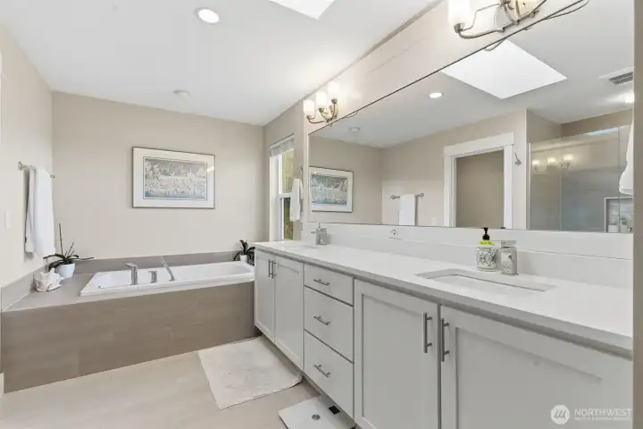 The primary bath features a luxurious soaking tub, perfect for unwinding after a long day. Elegant finishes and a spa-like atmosphere create a serene retreat right in your home.