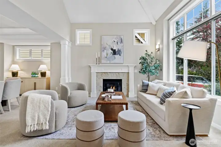 Front living room with gas fireplace, elegant millwork, and abundant natural light.