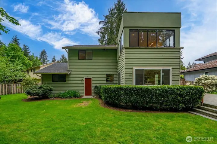 Fenced backyard is the perfect mix of green space for play and deck for entertaining.