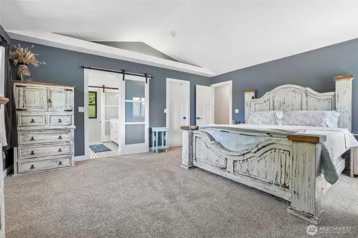 Large primary with vaulted ceilings and large walk in closet.