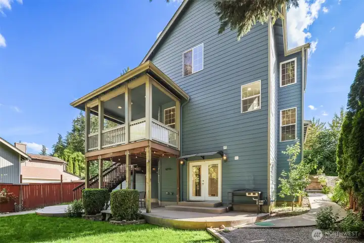 Rear of house with the poured concrete steps and patio in view.