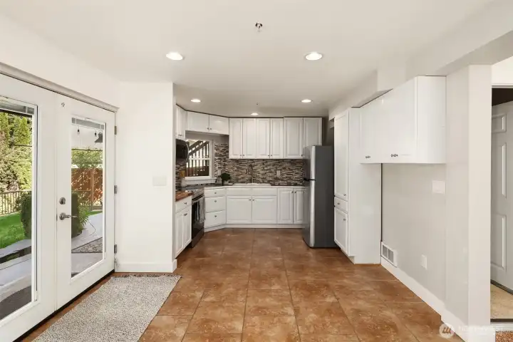 Lower level second kitchen.  French doors leading out with built in blinds.  This keeps the blinds dust free!