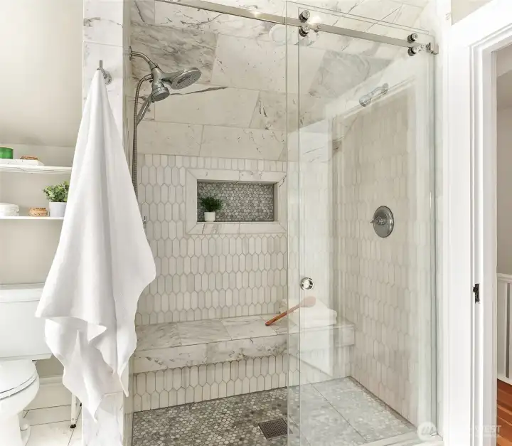 Gorgeous shower with marble tiles and a bench to soak it up. Gorgeous shower with marble tiles and a bench to soak it up.