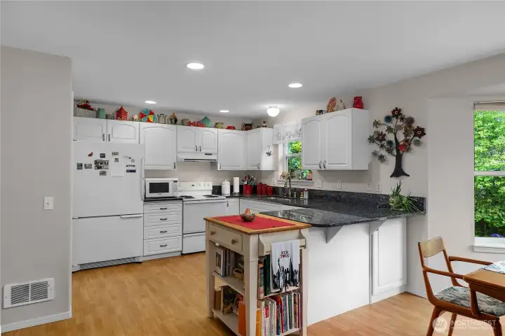 Spacious kitchen features granite countertops, white cabinetry, abundant workspace, and a convenient peninsula. Spacious kitchen features granite countertops, white cabinetry, abundant workspace, and a convenient peninsula.