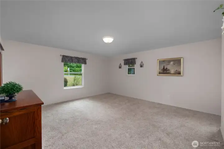 PBR - Spacious primary suite features plush carpet, abundant natural light, and room for oversized furnishings. PBR - Spacious primary suite features plush carpet, abundant natural light, and room for oversized furnishings.