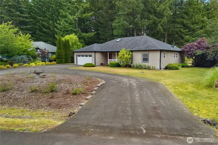 Attractive single-level home on a beautifully landscaped corner lot with circular driveway and mature trees. Attractive single-level home on a beautifully landscaped corner lot with circular driveway and mature trees.