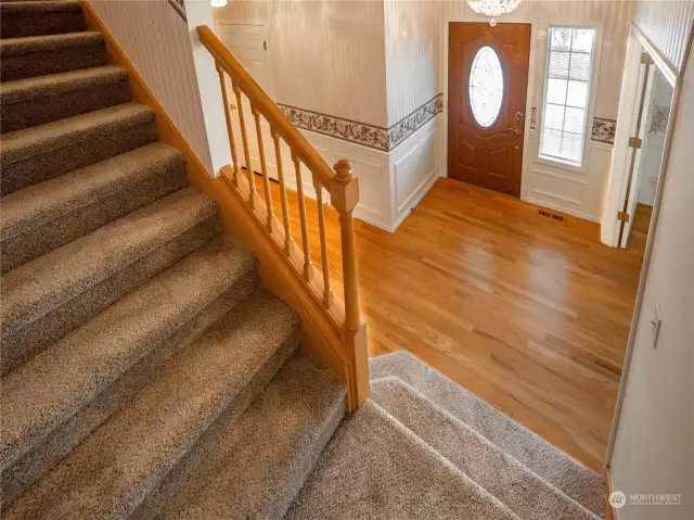 A view from the stairs landing to entry way.