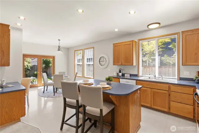 Kitchen is generous sized with an island counter, abundant cabinet space, and French doors that lead to the back patio.