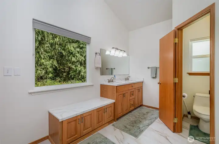 Spacious primary bathroom with dual sinks, plenty of storage, and separate water closet for extra privacy.