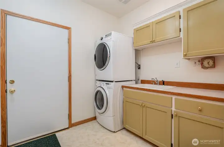Spacious laundry room equipped with a sink and abundant storage, providing a functional and organized space for all your laundry needs.
