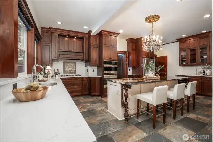 Beautifully renovated kitchen is made for entertaining. Just to the right of the double ovens, is the mud room and access to the upper deck and patio. Bright quartz counter tops are brand new.