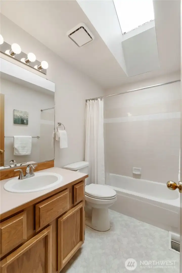 Upper level main bath with a skylight.