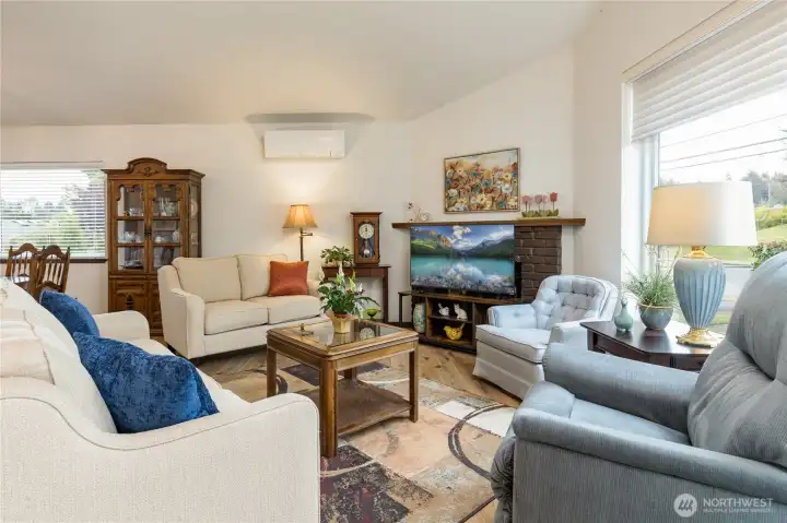 Airy living room featuring vaulted ceilings and a cozy fireplace for PNW winters, mini-split for the warm summer days.