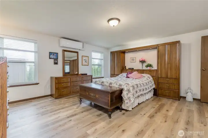 Spacious primary bedroom offers 2 large windows for natural light and a cool breeze.
