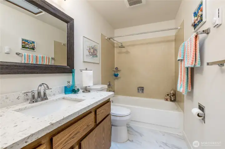 Full hall bathroom with updated flooring and quartz counter.