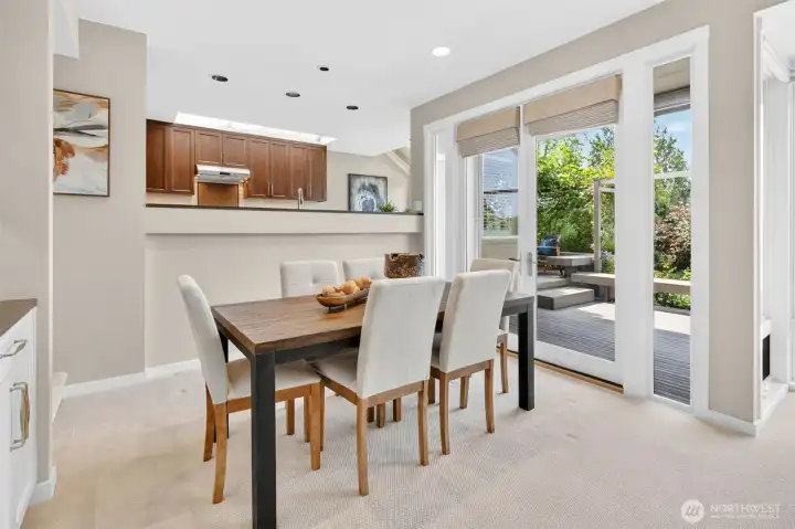 French doors open directly from the dining room onto the new 2024 deck, making al fresco dinners in the Ohashi-landscaped garden a seamless extension of every meal. A new skylight above the kitchen pass-through pours natural light into the space, while Hunter Douglas Roman shades offer effortless privacy when the occasion calls for it.