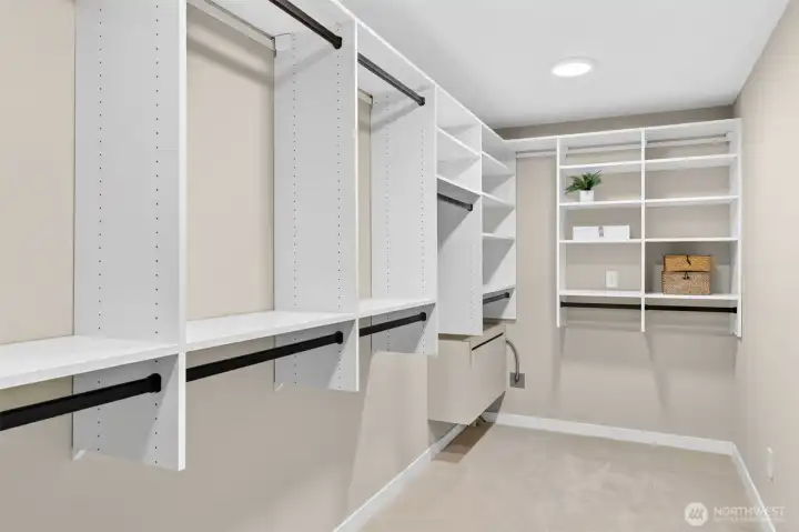 A custom California Closets system spans the full perimeter — double hang sections, open shelving, pull-out drawers, and a dedicated built-in ironing station make this walk-in as functional as it is generous. The kind of closet that finally gives your wardrobe the room it deserves.