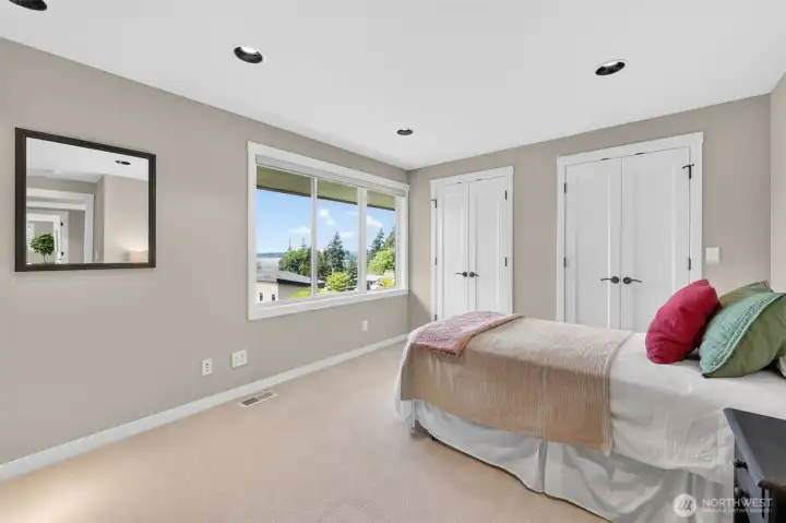 Bedroom 3, A well-proportioned upper-level bedroom with a peek of Lake Washington through the new windows and dual closets that give guests or family members more than enough room to settle in. Fresh carpet, neutral walls, and recessed lighting make it a blank canvas ready for whatever the next owner needs it to be.