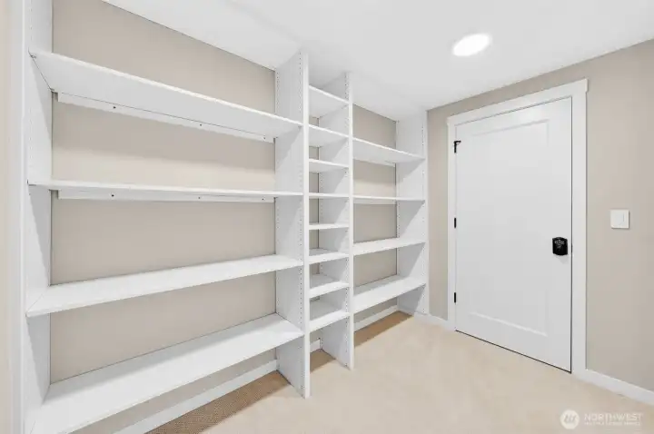 Behind the keypad-secured door lies one of this home's most practical luxury features — a dedicated room with floor-to-ceiling adjustable shelving on three walls, offering serious storage for valuables, collectibles, or anything that deserves its own protected space. Peace of mind, built in.