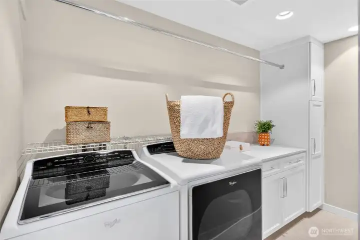 Laundry Room is conveniently located on the same level as the primary suite, this dedicated laundry room features a Whirlpool Cabrio washer and dryer, custom white cabinetry, quartz folding counter, and a full-length hanging rod — everything where you need it, exactly when you need it.