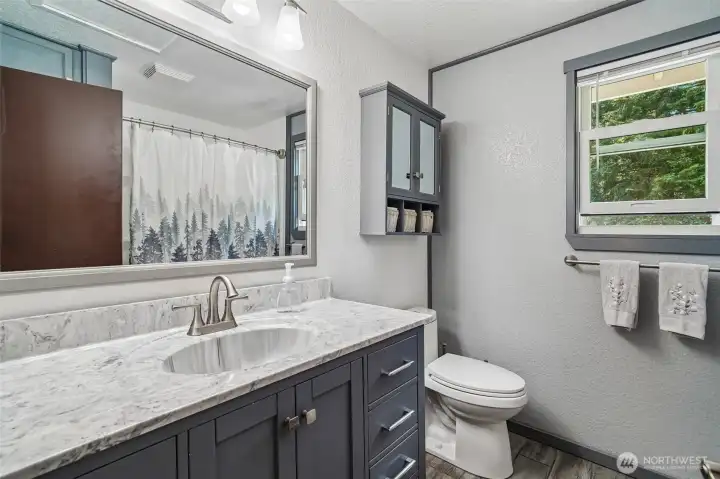 Upstairs bathroom with Luxury Vinyl flooring, full bath, and large mirror