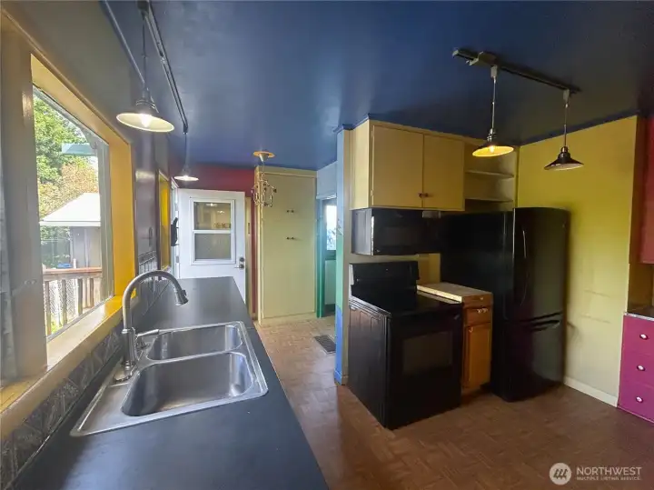 Very spacious kitchen with tons of storage! Entry to laundry/utility room behind open back door. Bathroom to the right.