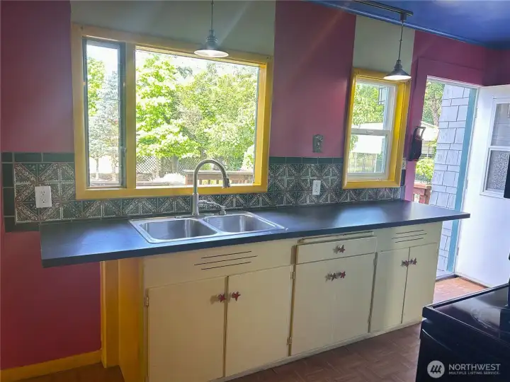 Enjoying a peaceful view of the backyard from the kitchen. Entry to dining room/living room to the left.