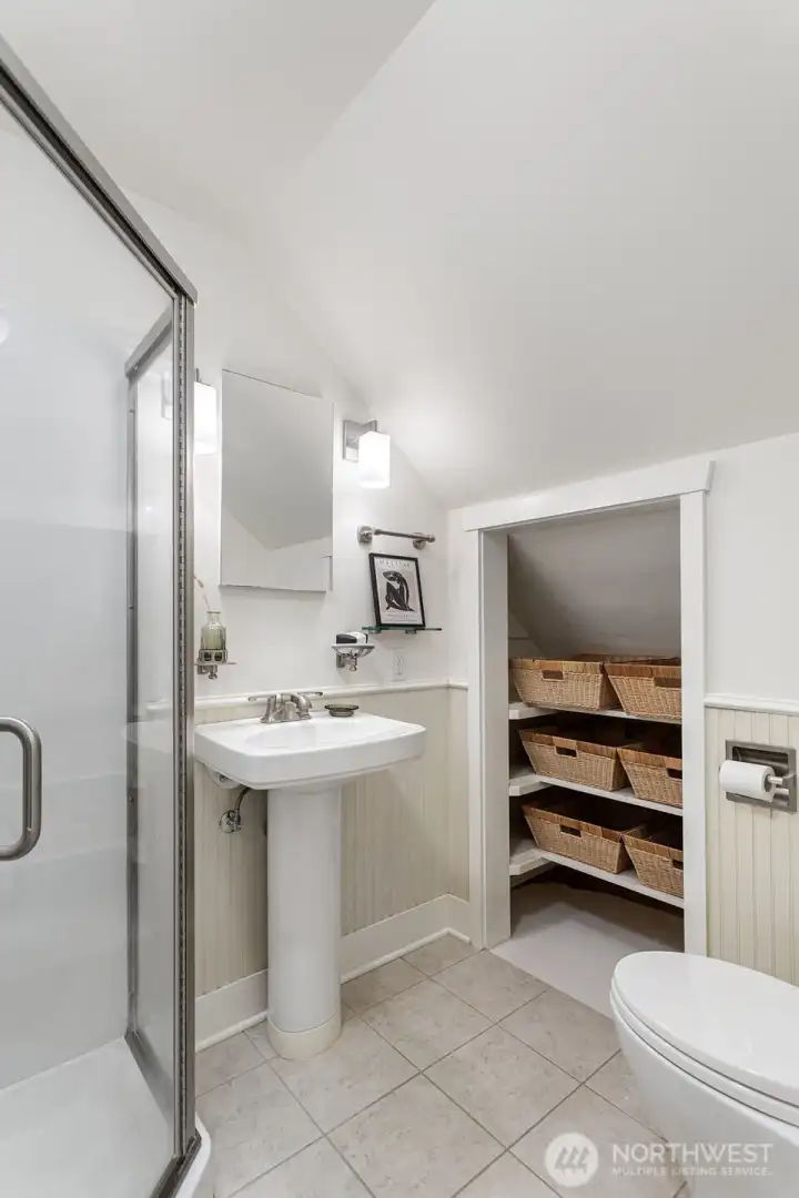 Primary en-suite bath with storage and pedestal sink.
