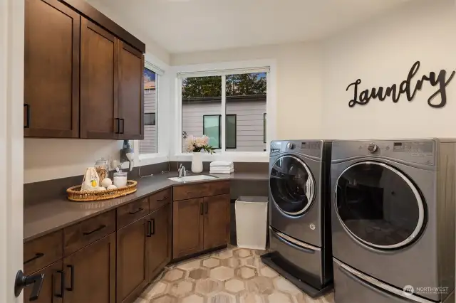 Generous laundry room includes utility sink and plenty of storage space