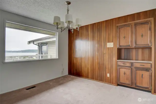 Next to the living room is the formal dining room with wood paneling and a built in wood hutch for your fine china and service ware. While you dine you can take in the views through the large picture window.