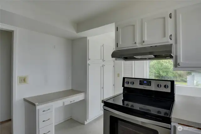 Kitchen has plenty of cabinetry for storage space and a small work desk for an online tasks.