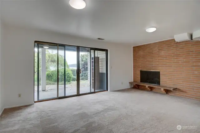 Family Room area with sliding glass doors out to back yard & patio. Brick wood-burning fireplace. Also side door for access to 2-car garage.