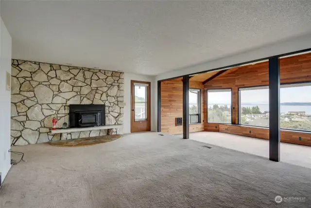 Living room is highlighted by an enormous natural stone fireplace with a wood-burning insert, for the cold nights in the winter. Doorway gives access to large view deck.