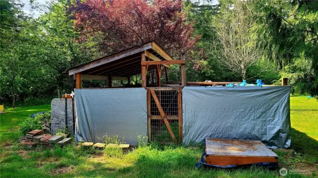 The covered storage area for wood.  In front is small sandbox.
