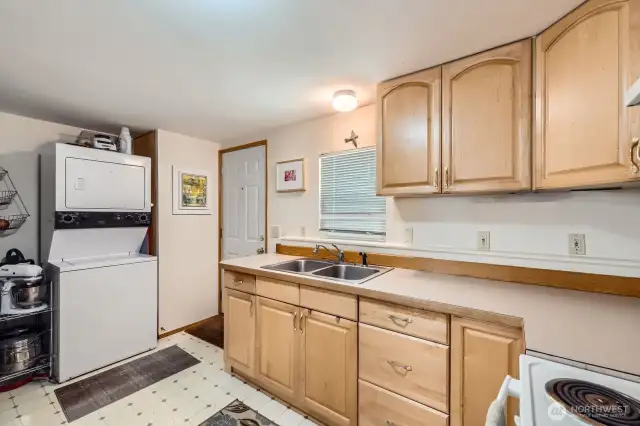 This shows entry door to ADU, kitchen, and stackable washer/dryer. Has it's own water heater next to the laundry.