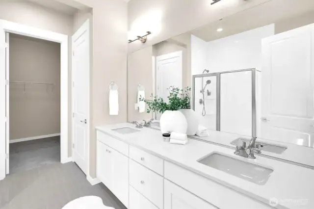 Roomy spa-like bathroom with dual sinks and modern finishes.