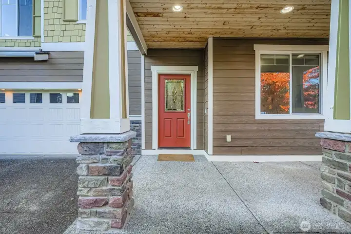 Covered entry porch with inviting red door.