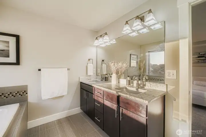 En suite bath with dual sinks, soaking tub, and walk-in shower