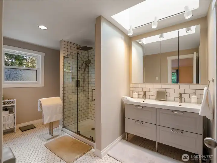 The primary bathroom is stunning! Features subway tile backsplash and walk-in shower surround. Classic hexagon tile floors elevate the space. Double sinks and skylight make this an incredible room.