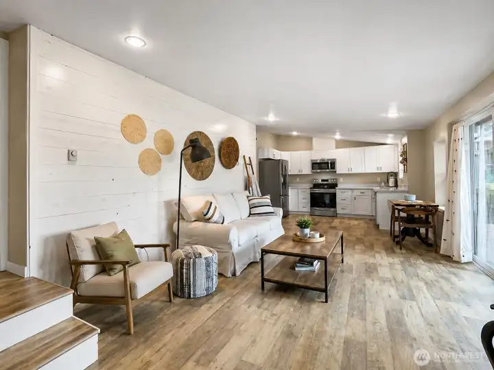 Great room from the entry door.  Steps at left go to the 2nd bedroom.  Partial virtual staging.