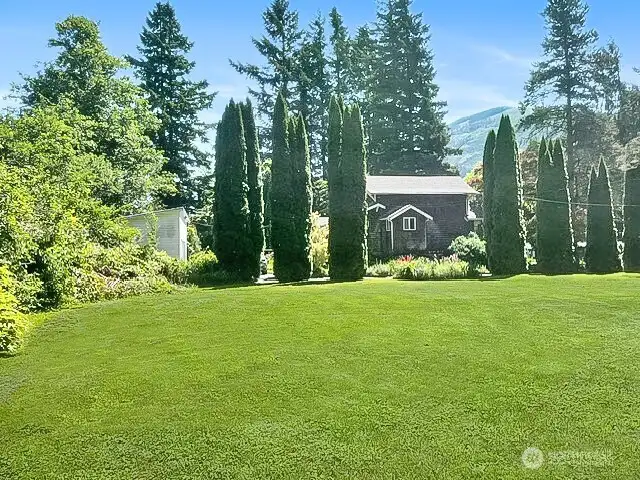 East side  of the house showing large side yard. Garage is the white building to the left.