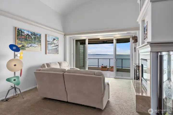 The living room with its tall, vaulted ceilings is an ideal space for entertaining, where you can enjoy the constant parade of marine life, ferries, herons, and eagles passing by.