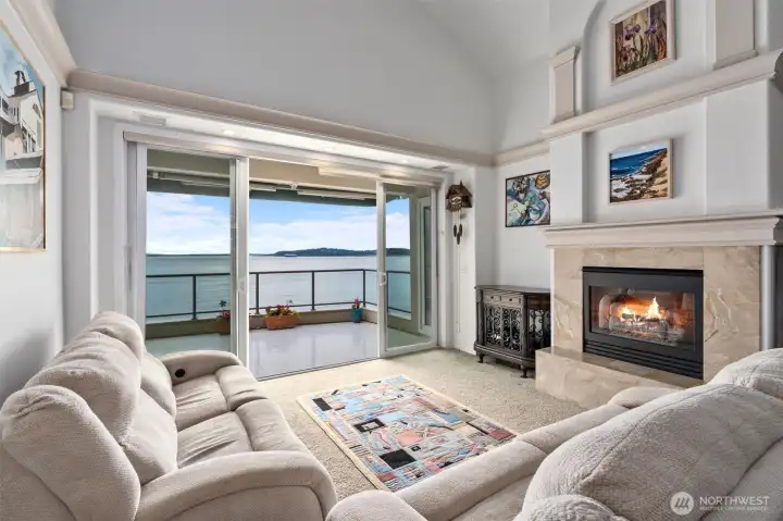 The living room offers double sliding doors leading to a large view lanai and is anchored by a warm, inviting gas fireplace.
