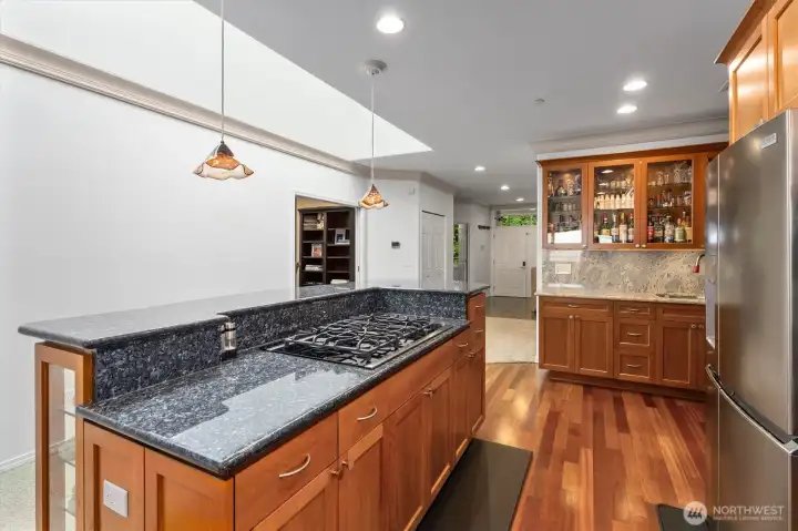The gas cook top is located on the kitchen island and out of sight it the electric oven and microwave.