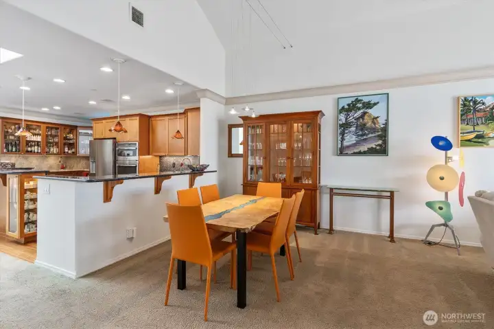 Living room to the right, dining area in the foreground and kitchen to the left.