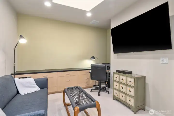 The versatile media room/home office features a large skylight and pocket doors.