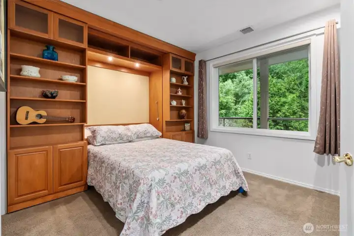 The peaceful guest room has a walk-in closet and this beautiful built-in murphy bed; located on the opposite side of the unit from the primary providing privacy.