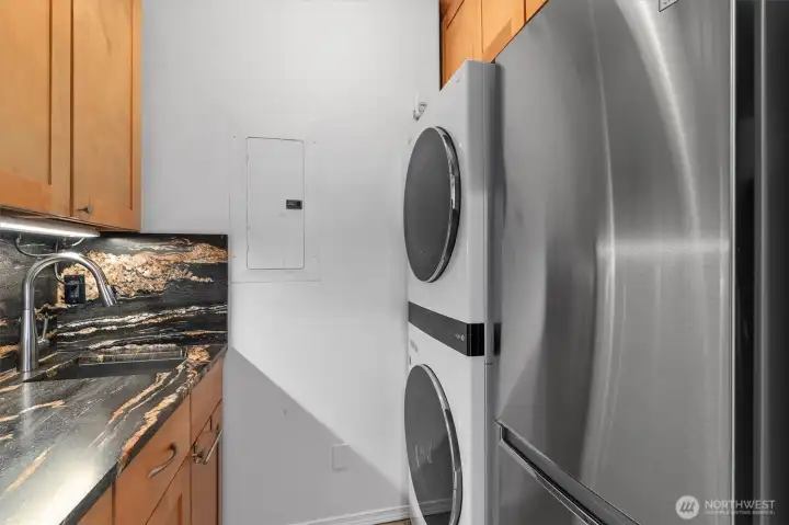 The updated and versatile laundry room offers both style and functionality, thoughtfully designed to maximize utility and convenience. Complete with stacked washer and dryer units and an additional refrigerator, this flexible space has even doubled as an extra serving and prep station during gatherings and parties—perfect for effortless entertaining.